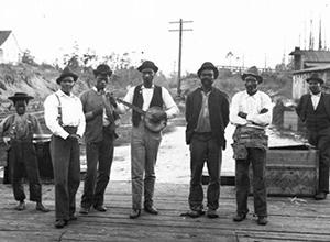 Black and White image of men singing and playing guitar.